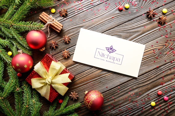 Weihnachtsgutschein liegt auf einem Tisch neben Weihnachtsdekoration